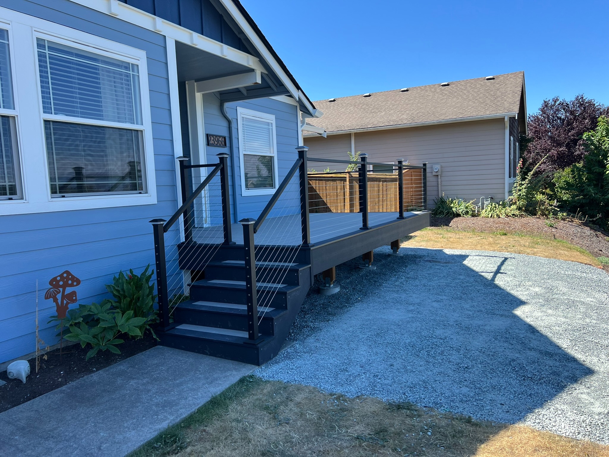 Completed gray deck with black metal posts and cable railing