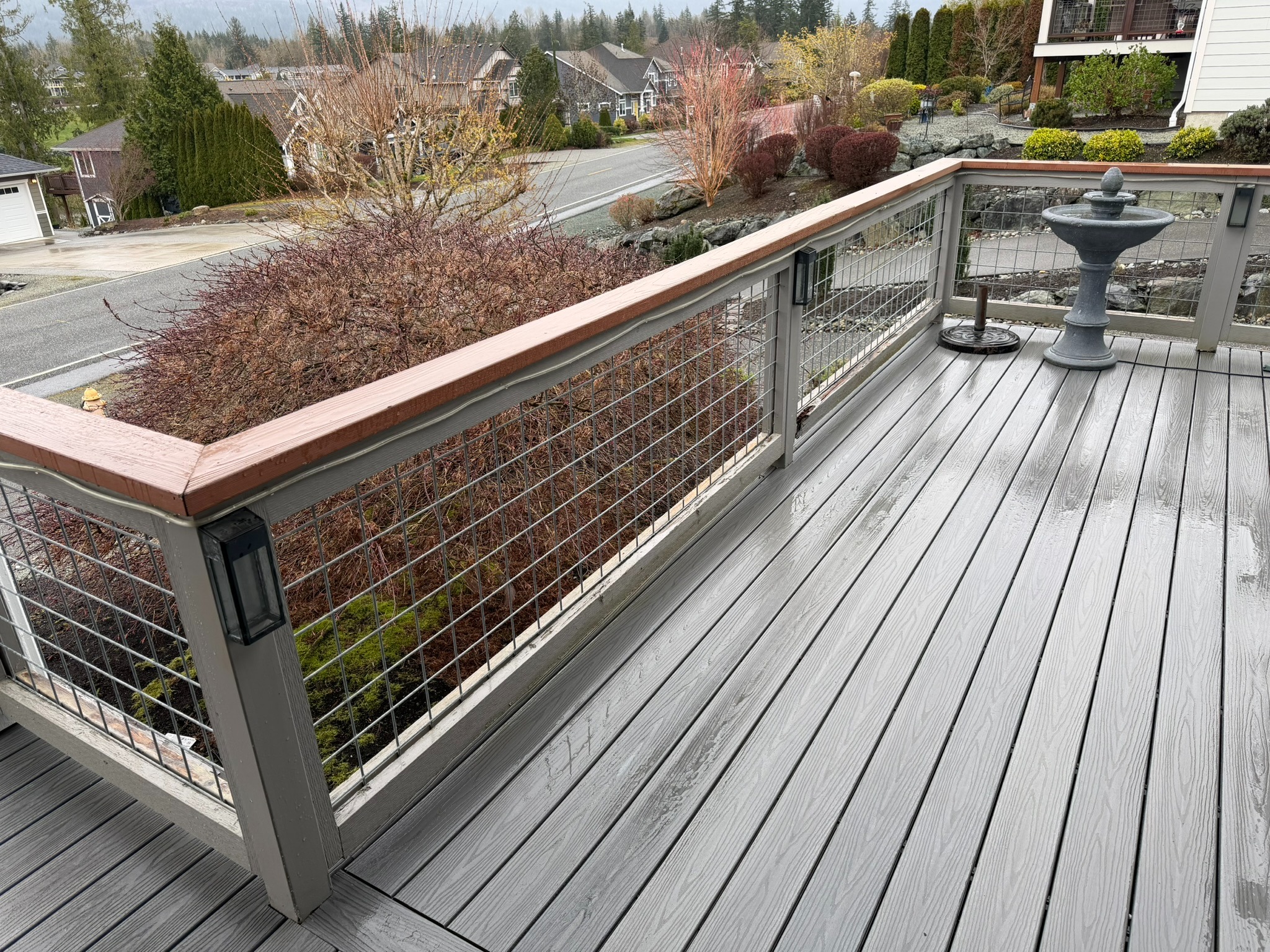 Finished gray composite deck with wood-capped cable railing